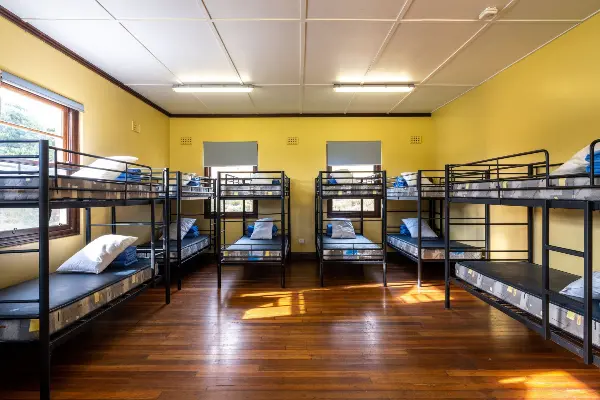 Six bunkbeds in a dormitory.