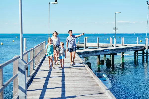 Family of four walking along a jetty.