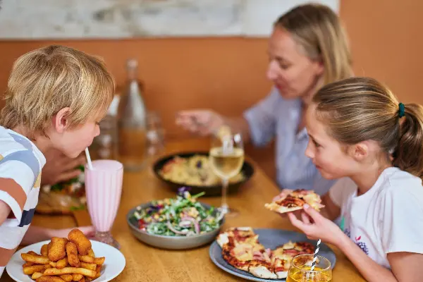 Family enjoying pizza and refreshing beverages at Frankie's on Rotto