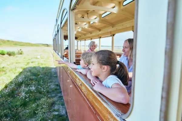 Children looking out from a window on the Captain Hussey Train Tour.