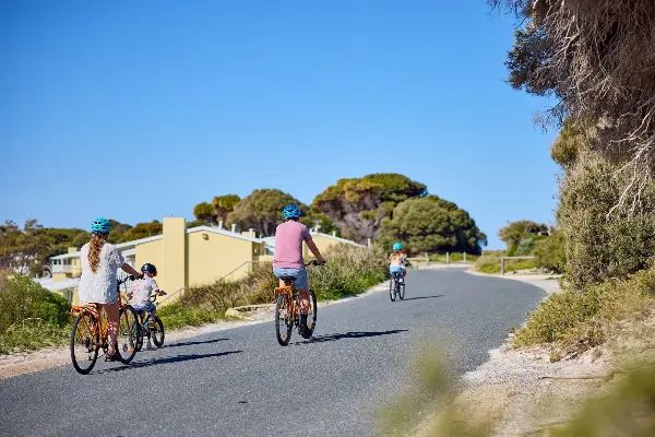 A family of four cycling together on Wadjemup / Rottnest Island.
