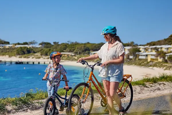 Mother and son with bikes at Geordie Bay on Rottnest Island.