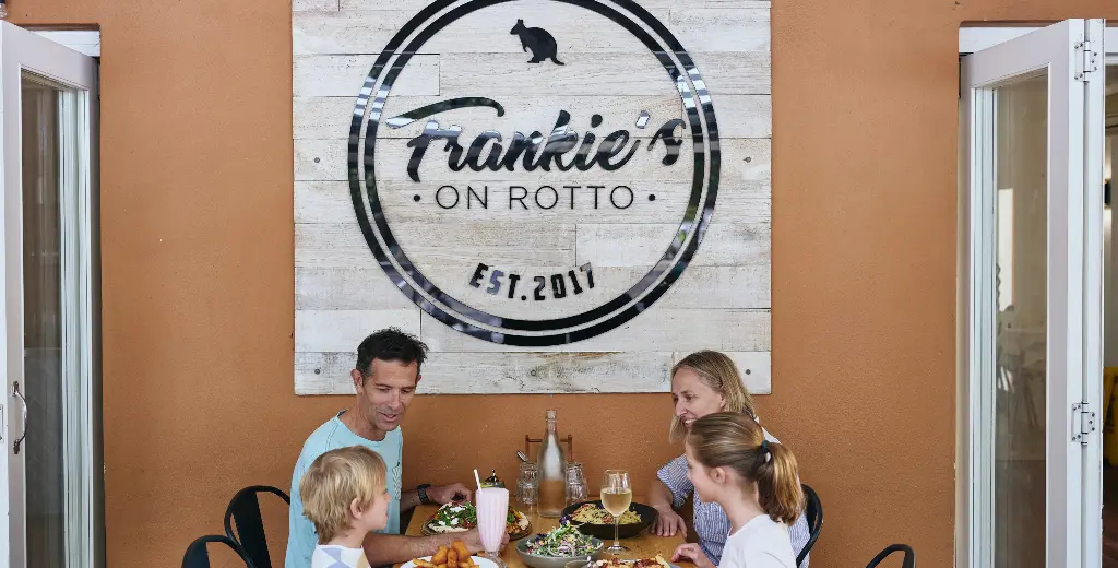 Family enjoying food outside underneath the Frankie's on Rotto sign
